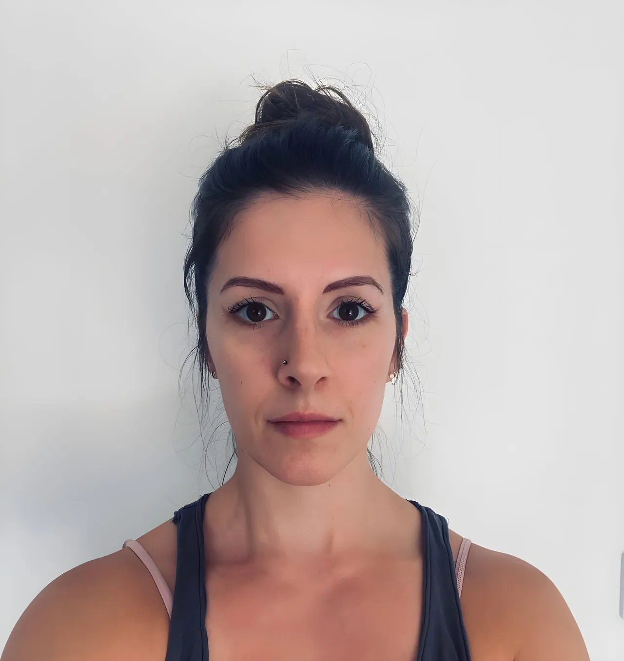 Jen, founder and teacher at Moku, photographed against a plain pale wall