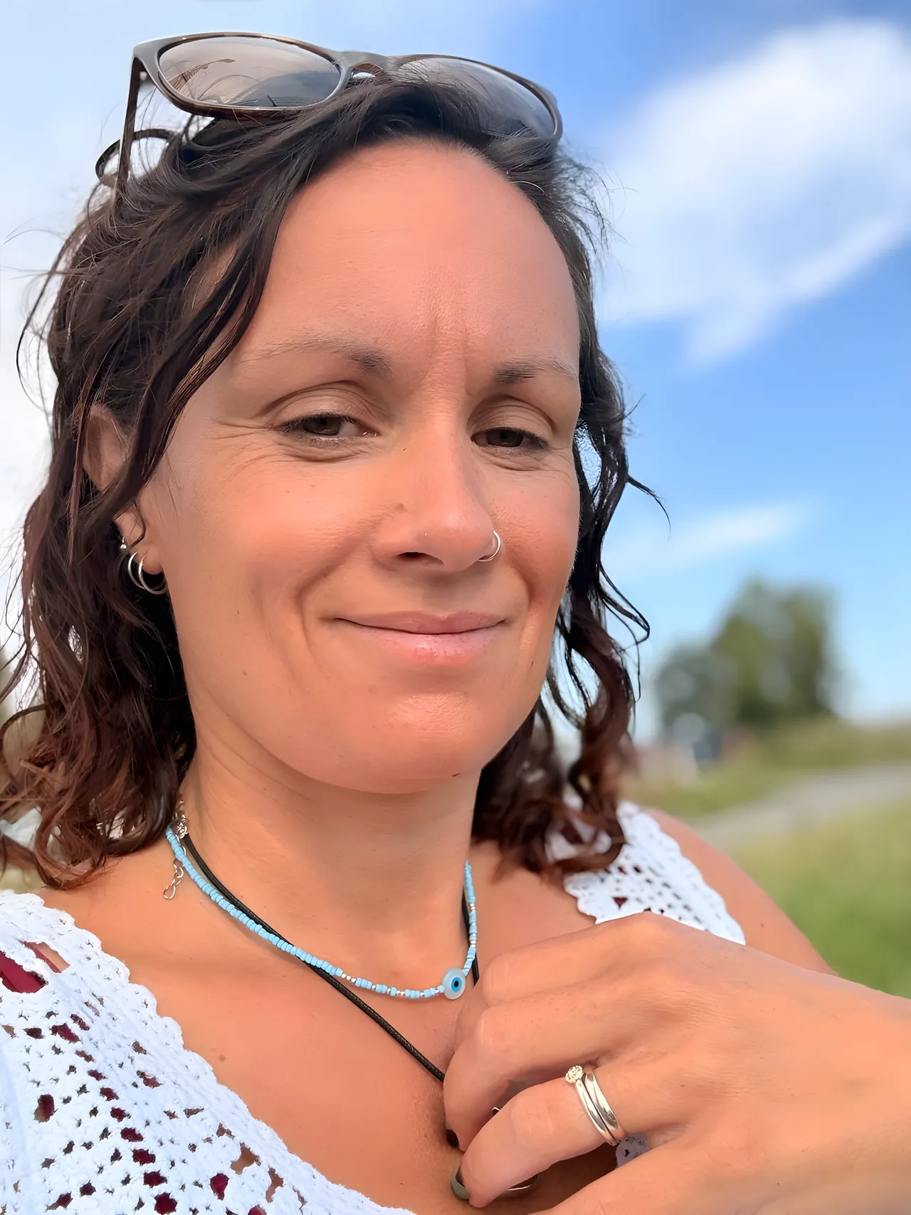 Sarah, beginner and Hatha yoga teacher, photographed outside with a blue sky